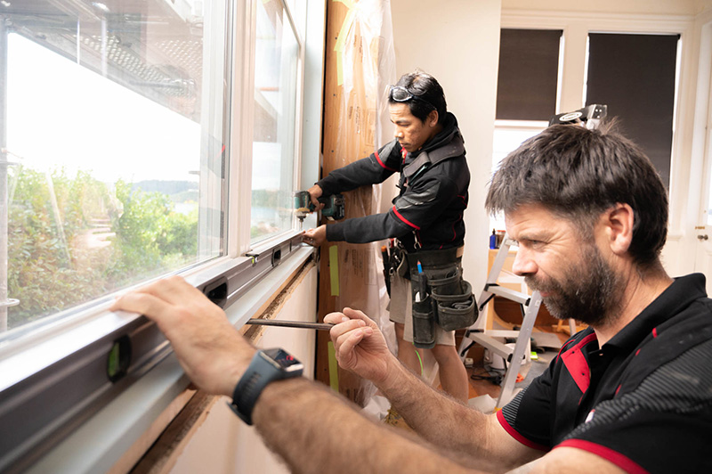 Lockhart Construction crew installing new windows into renovated house
