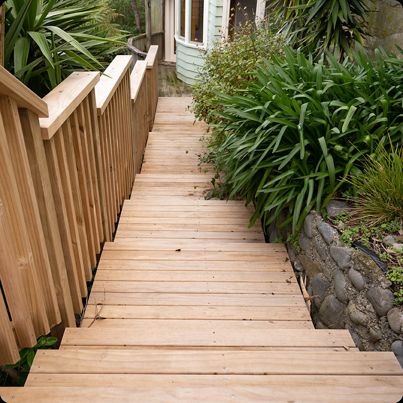 Wooden stairs and railing leading down to house