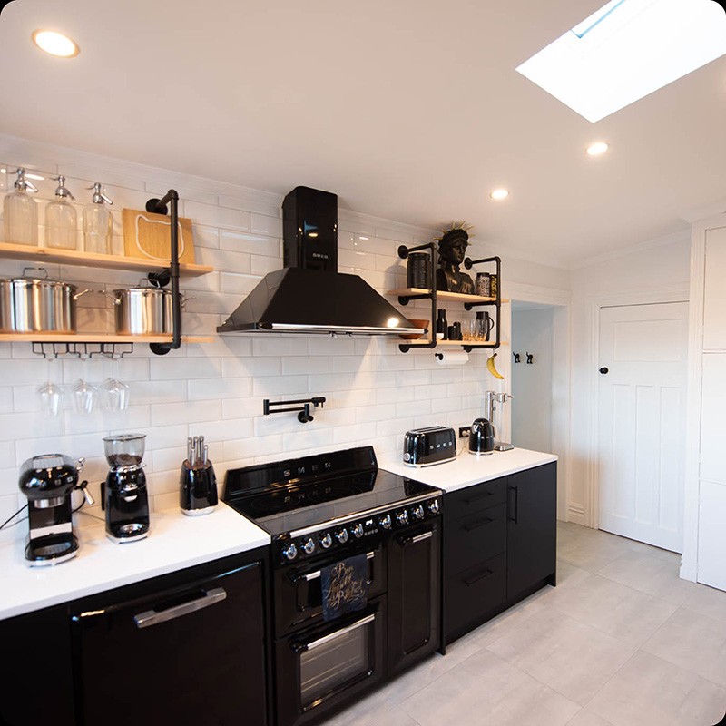 Renovated kitchen with wooden industrial open shelves, white tiles and black cabinetry